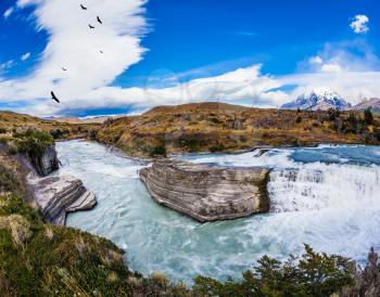 Cold water is emerald Paine river forms a cascading waterfalls. Chile, Paine Cascades. National Park Torres del Paine - Biosphere Reserve