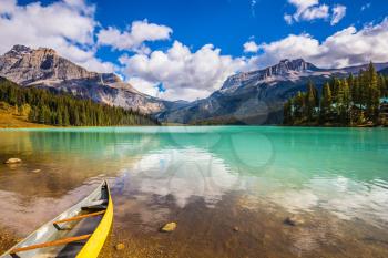 In shallow water the small boat is moored. The concept of eco-tourism and active tourism. The mountain Emerald lake Yoho National Park