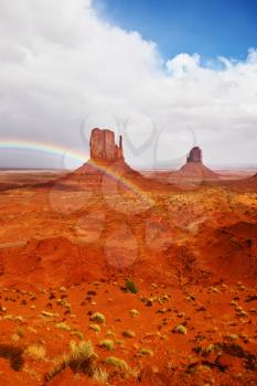  Certain rocks - mitts are crossed with a picturesque rainbow. Red stone desert of an Indian tribe of the Navajo, USA