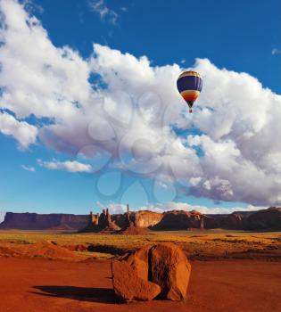 Huge balloon flies over the red desert. Monument Valley in the Navajo Indian Reservation. Arizona, USA