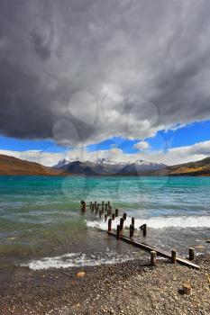 National Park Torres del Paine in Patagonia, Chile. Boat dock on the lake. Storm clouds, wind and waves at the Laguna Azul. 