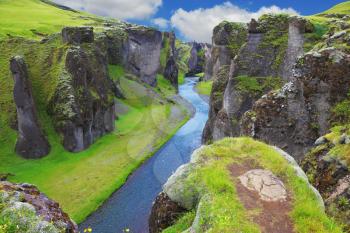 Neverland Iceland. The picturesque canyon Fjadrargljufur, green cliffs and blue water of the river