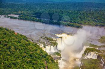 Iguazu River spreads widely among the dense tropical forests. Devil's Throat - largest waterfall of the Iguazu Falls. Picture taken from a helicopter