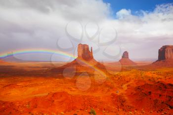 Red stone desert Navajo, USA. Isolated rocks - mitts intersect with the beautiful rainbow