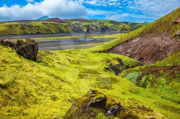Canyon Pakgil in Iceland. Basalt hills covered with green grass and moss. Streams from melting glaciers flowing down the canyon