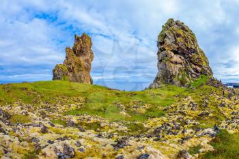 Gorgeous Iceland. North sea coast. Fantastic ancient rocks covered with green and yellow moss
