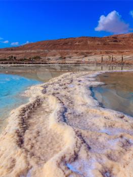Path from the evaporated salt on a water surface. The Dead Sea at coast of Israel