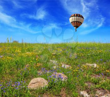 Flowering Golan Heights in a beautiful sunny day. In a clear sky flying big colorful balloon
