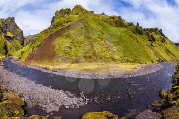 The canyon Pakgil is located among fantastic rocks. On bottom of canyon  fast shallow stream flows. The summer blossoming Iceland. The photo was taken Fisheye lens