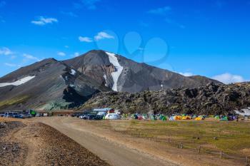 Rhyolite mountains surround the flat valley of National Park Landmannalaugar. Big tourist camp is located in the valley of the park