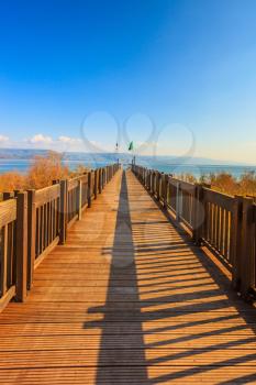 Wooden pier leading to the famous Sea of Galilee. Sunset on the lake of Kinneret