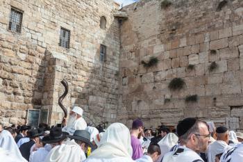JERUSALEM, ISRAEL - OCTOBER 12, 2014: The area in front of Western Wall of  Temple filled with people. Elderly religious Jew with a Shofar. Morning autumn Sukkot