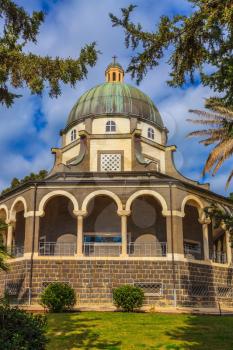 Church Sermon on the Mount - Mount of Beatitudes. The basilica is surrounded by a gallery with columns. Subtle shade of palms and cypresses