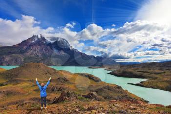 Strong winds in the Chilean Patagonia. National Park Torres del Paine, Lake Pehoe. The woman raised her hands with delight the beauty of nature