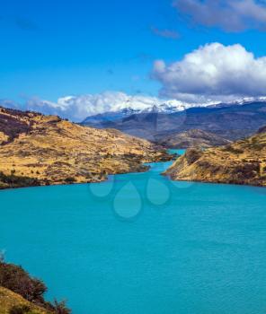 Rio Paine - the emerald water of the river among hills of the park. Torres del Paine National Park. Summer in the south of Chile. The concept of extreme and active tourism