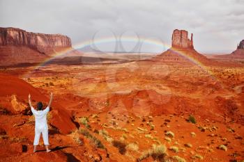 Navajo Reservation in the US. Red Desert and rocks - mitts sandstone. Woman in white performs asana Sun salutation