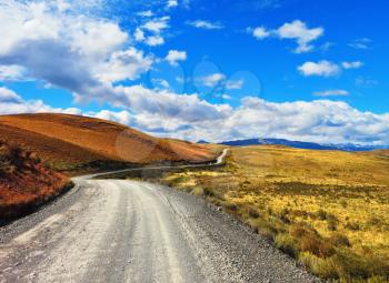 Magic country Patagonia. Gravel road between the colorful hills. National Park Torres del Paine in Chile