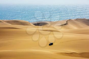 Atlantic coast of Namibia, south of Africa. Fantastic jeep - safari through the huge sand dunes on the ocean shore. The concept of exotic and extreme travel