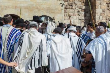JERUSALEM, ISRAEL - OCTOBER 12, 2014: Morning autumn Sukkot. The area in front of Western Wall of  Temple filled with people. Crowd of faithful Jews wearing prayer shawls