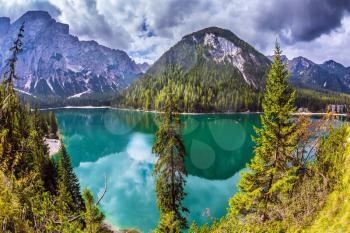  Water reflects mountains and forest. The concept of environmental and hiking. Walk around the lake Lago di Braies, South Tyrol, Italy