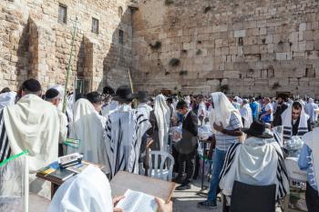 JERUSALEM, ISRAEL - OCTOBER 12, 2014:  Huge crowd of faithful Jews wearing white prayer shawls and black long-skirted coats. Morning Sukkot