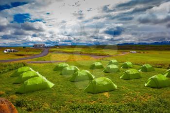 Boy Scout Campground in Iceland. Green tent on a grassy lawn. July in the Arctic