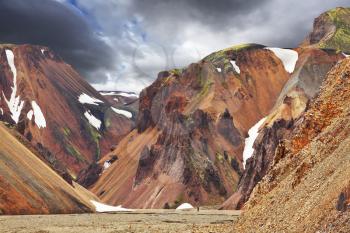 Multicolored rhyolite mountains with the remnants of last year's snow in July. The famous Valley Landmannalaugar in Iceland