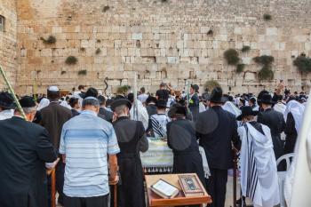 JERUSALEM, ISRAEL - OCTOBER 12, 2014:  Huge crowd of faithful Jews wearing white prayer tallith and black long-skirted coats. Morning Sukkot