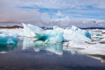Ice splendor. Iceland. Floating ice and clouds reflected in the mirror-smooth water lagoon Ice