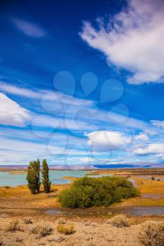 Yellow flat desert with shallow lakes. Argentine Patagonia on a windy day