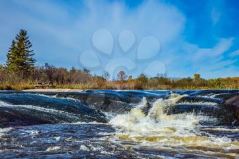 Foam water rapids on the smooth stones of the Winnipeg River. Old Pinawa Dam Provincial Heritage Park. The concept of travel Around the World