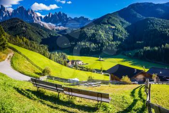 Picturesque Val di Funes. Sunny autumn day in Dolomites, Tirol. Rocky peaks and forested mountains surrounded by green Alpine meadows