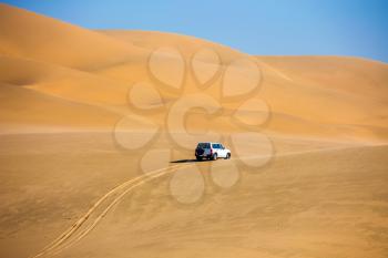 The concept of exotic and extreme tours. Magical jeep - safari through sand dunes on the ocean coast. Atlantic shore of Namibia, south of Africa