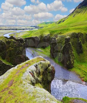 Fantastic country Iceland. The most picturesque canyon Fjadrargljufur  and the shallow creek, which flows along the bottom of the canyon