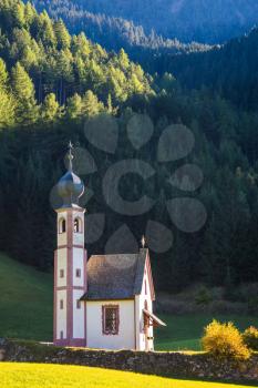  The church of Santa Maddalena. Tirol, Dolomites. Rocky peaks and forested mountains surrounded by green Alpine meadows. Sunny warm autumn day