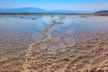 The Dead Sea at coast of Israel. The path forms freakish patterns on a water surface of the evaporated salt