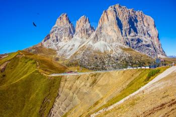 Indian summer in the Tyrol. Magnificent ridge of dolomite rocks on the Sella Pass, Dolomites. Picturesque road through the pass. The concept of extreme and ecological tourism