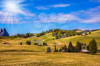 The winter ski resort. Autumn sun illuminates the hills. The landscape of the Alps di Siusi. The concept of an active and eco-tourism
