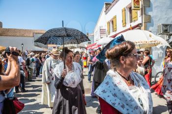 Saintes-Maries-de-la-Mer, France - May 25, 2015. Religious feast in honor of the Holy Maries in Provence. Women in vintage dresses and with umbrellas. The concept of ethnographic tourism