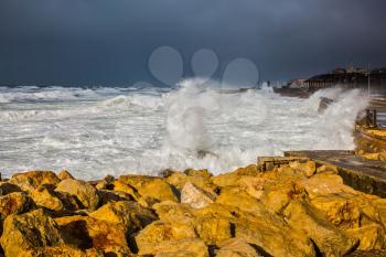  Huge foaming waves beating against the shore. Strong storm in the Mediterranean Sea. New Quay in the Old Jaffa, Israel