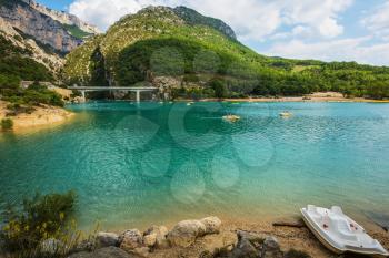 Big bridge over river Verdon in Provence.  White catamarans are sailing on turquoise water. National park Merkantur, France