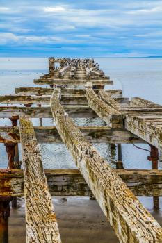  Rusted and destroyed remains of the sea mooring. South of South America. The legendary Strait of Magellan. Cloudy autumn morning. The concept of extreme and active tourism
