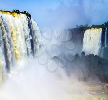 Iguazu Falls in South America, on the border of two countries: Brazil and Argentina. Concept of active and extreme tourism. World of falling water