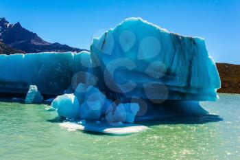 Argentine Patagonia, Lake Viedma. A huge white-blue iceberg floats away from the glacier on a warm summer day