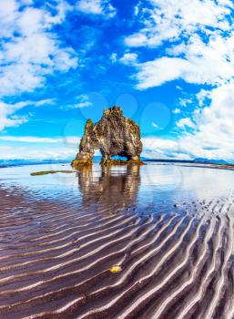 Rock Hvitsevkur on the sea beach in the form of a huge mammoth. The north coast of Iceland. The concept of extreme northern tourism. Ocean tide at sunset