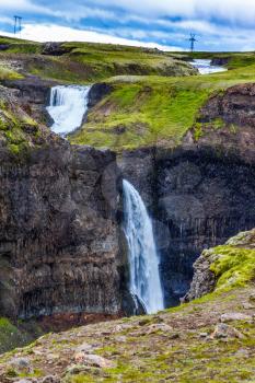 Complex of high waterfalls of Haifoss in a dangerous tundra canyon. Cloudy and windy summer day in Iceland. The concept of extreme and phototourism