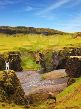 Fantastic country Iceland. Woman dressed for yoga on a rock canyon  Fjadrargljufur