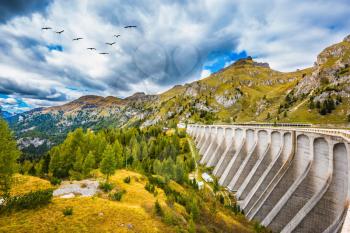 Powerful dam blocked the lake. Mountain Lake Lago di Fedaia, Dolomites. The concept of ecological and extreme tourism