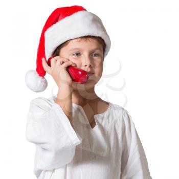 Very beautiful seven year old boy in a red cap. He is talking on the red phone