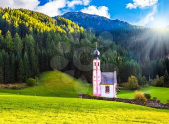 The summer sunset, Dolomites, Tyrol. The famous church of St. Mary Magdalene and bell tower in a mountain valley. The concept of eco-tourism 